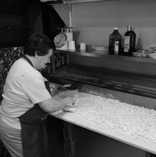 Mama Rosa hand-rolling fresh gnocchi in the kitchen at Justino's